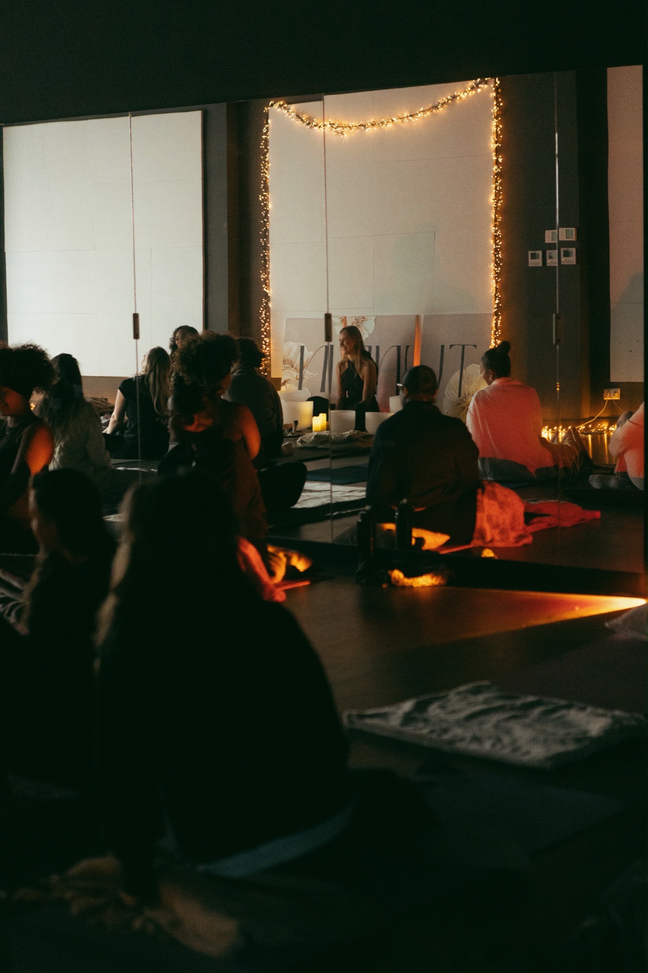 A larger group sound bath gathering in candlelight at Tune In in Rotterdam
