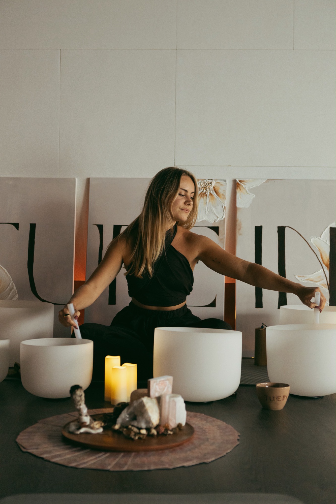 Sem playing two crystal singing bowls during a private sound healing session